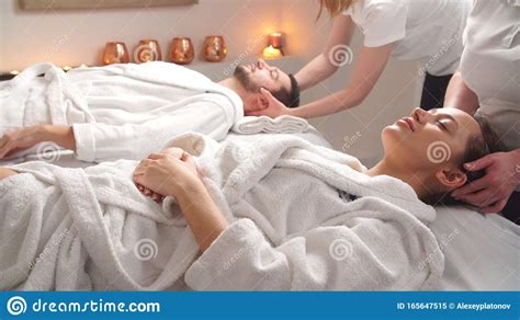Beautiful Couple Lying Down On Massage Beds Enjoying A Head Massage In