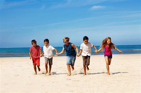 Many Children Run Together Holding Hand On A Beach Stock Image Image