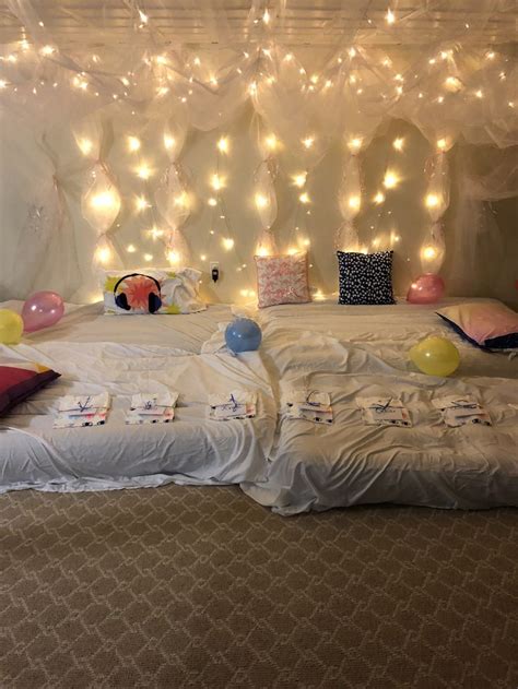 an unmade bed with balloons and streamers hanging from the ceiling