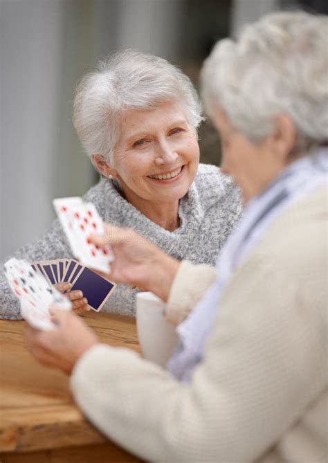 Helping The Time Pass With Card Games Two Senior Women Playing Cards Together Stock Image
