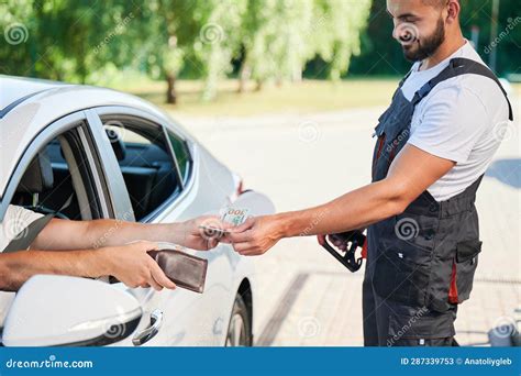 Customer Paying by Cash To Smiling Gas Station Operator Stock Image