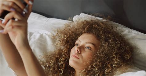 A Woman Taking A Selfie While Lying In Bed · Free Stock Video