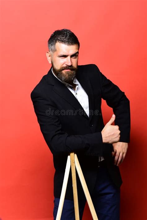 Masculinity And Style Concept Macho Man Leans On Tripod Stock Photo