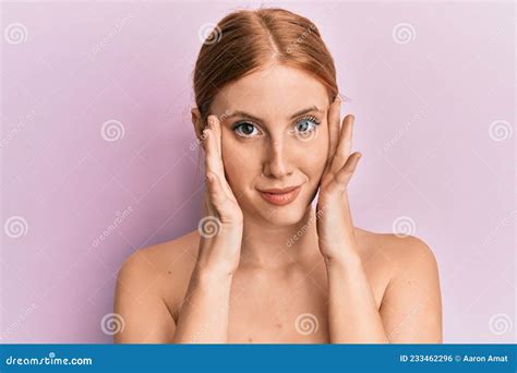 Young Irish Woman Standing Topless Stretching Skin Face With Hands