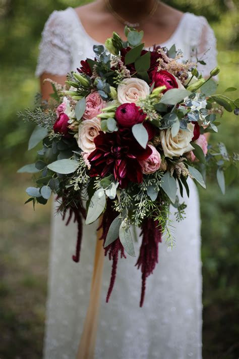 Perhaps the couple was only able to have a small wedding or elopement and now wish to have more. Bridal bouquet, Rich red dahlias and garden roses (With ...