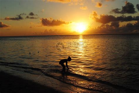 日落时在海滩上玩海浪的女孩的休眠水高清图片下载 正版图片503910507 摄图网