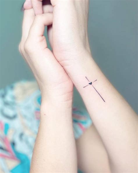 Minimalistic Cross And Heart Tattoo Located On The