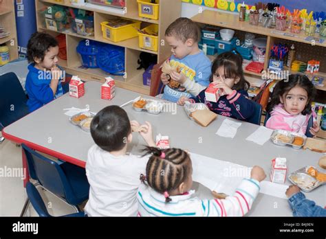 Los niños preescolares comer el almuerzo en el aula Fotografía de stock