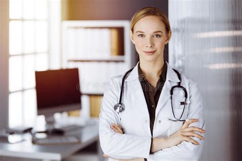 Cheerful Smiling Female Doctor Standing In Clinic Portrait Of Friendly
