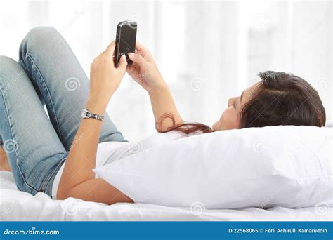 Woman Texting On Phone Lying On Bed Royalty Free Stock Photo Image