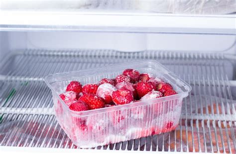 Frozen Strawberries In A Plastic Container In The Freezer Stock Image