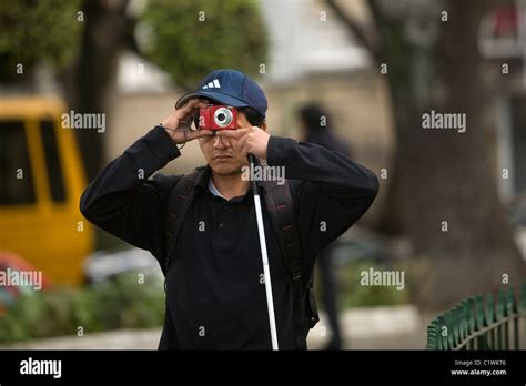 A Blind Photographer Takes Pictures During A Photography Workshop For