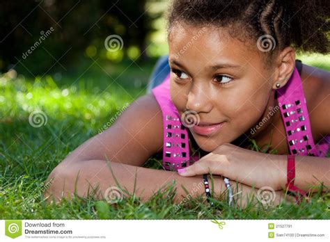 Young Black Teenage Girl Lying On The Grass Stock Image