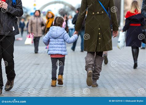 Mother And Daughter Walking On City Street Among Crowd Stock Photo