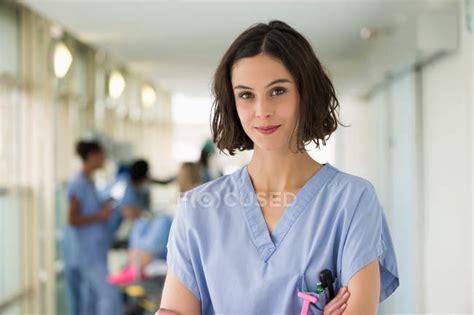 Portrait Of Smiling Female Nurse Standing With Arms Crossed — Expertise
