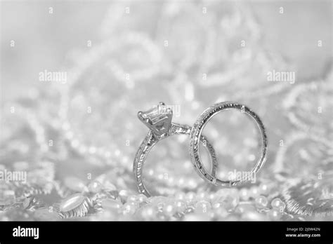 Diamond Wedding And Engagement Rings On A Pearl Lace Background Stock