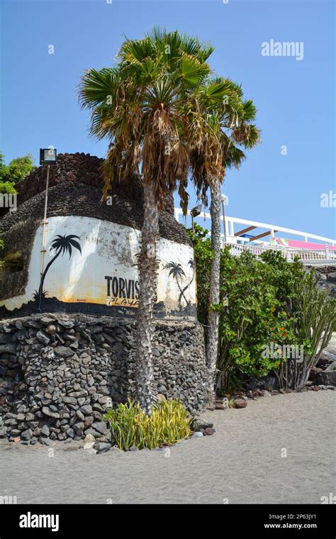 Torviscas Playa Lettering On A Stone Wall On The Beach With Palm Trees In Costa Adeje Tenerife