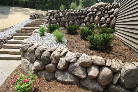 Custom Landscaping With Stone Retaining Wall And Wood Chips Stone