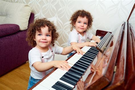 Premium Photo Two Funny Twin Playing The Piano Together Smiling