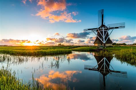 Download Sky Sunrise Reflection Building Man Made Windmill Hd Wallpaper