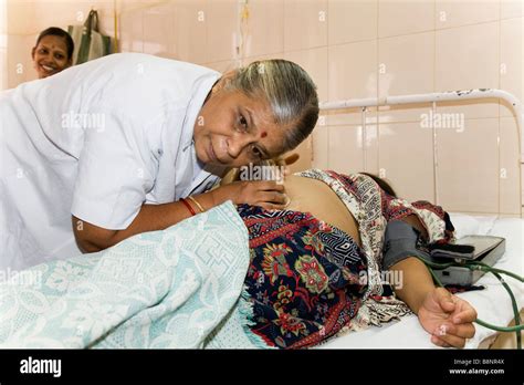 Maternity Nurse Listens To Monitoring Heart Unborn Baby Of Pregnant