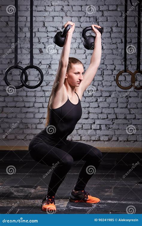 Young Fitness Woman Doing Crossfit Workout With Kettlebell Against