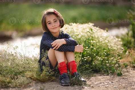 Little Girl Sitting In Nature Field Wearing Beautiful Dress 4521116