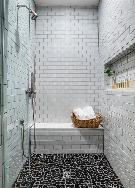 When choosing river rocks for your shower floor, it is always a good idea to seal the rocks so they can fight off stains. Black river rock tiles accent a walk-in shower boasting a ...