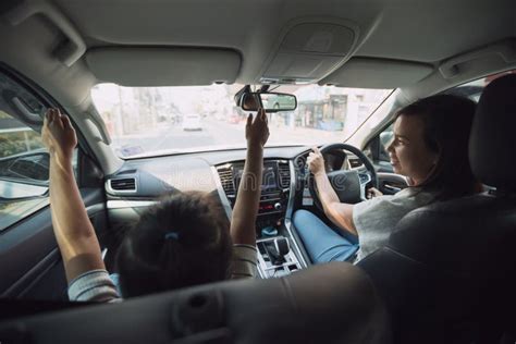 Asian Mother Driving A Car With Her Daughter Traveling To School Together With Happiness Stock