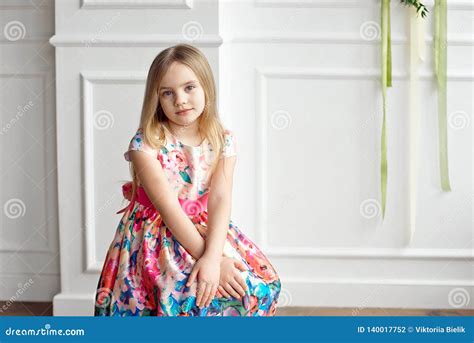 Portrait Of Little Smiling Girl Child In Colorful Dress Posing Indoor