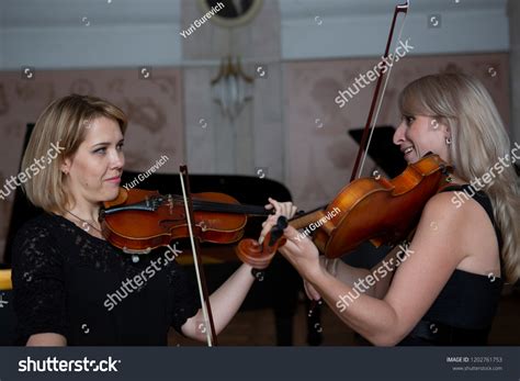 Two Beautiful Female Violinists Playing Violin Stock Photo 1202761753
