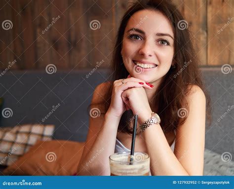 Beautiful Cute Brunette Girl Sitting In The Cozy Cafe Near The Window