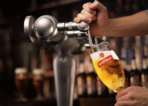 A Person Is Pouring Beer Into A Glass