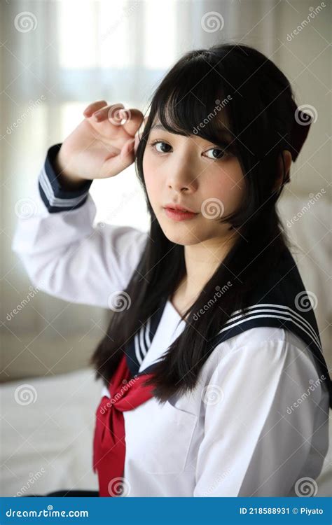 Japanese School Girl Sitting On Bedroom In White Tone Stock Image