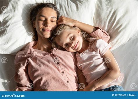Calm Mother And Daughter Sleeping Together In Bed Above View Stock