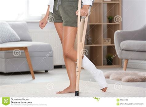 Young Woman With Crutch And Broken Leg In Cast At Home Stock Image