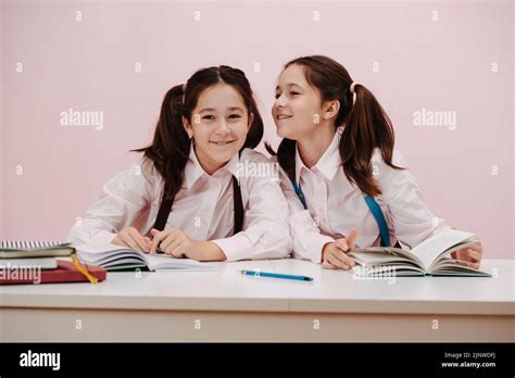 Gossiping Curious Schoolgirl Twins Sitting Behind The Desk With