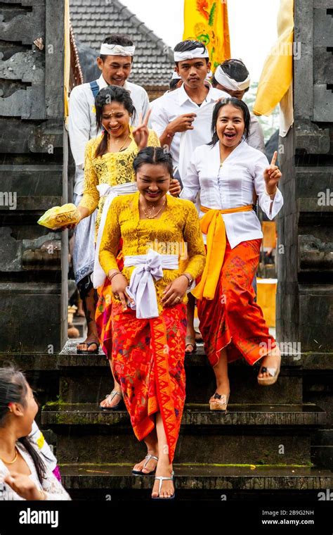 A Group Of Young Balinese Hindu People Leaving A Temple During A Local