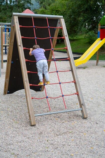 Premium Photo A Boy Not Recognizable Climbs A Rope Ladder In A