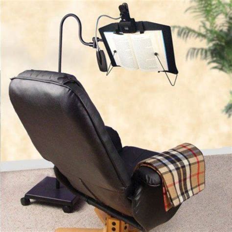 A Black Chair With A Book On It And A Light Attached To The Armrest