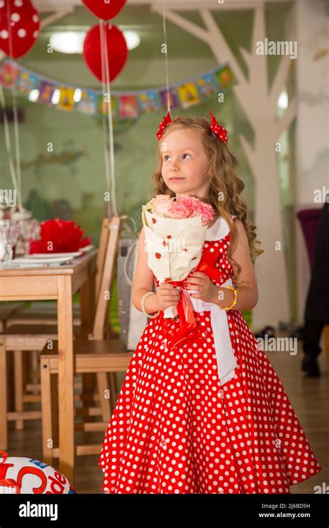 Happy Kid Girl Celebrating Birthday Party With Bouquet Of Flowers In