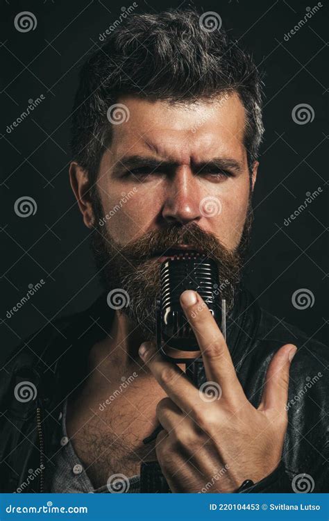 Male Vocalist Singing In Microphone In Recording Studio Handsome Bearded Man In Leather Jacket