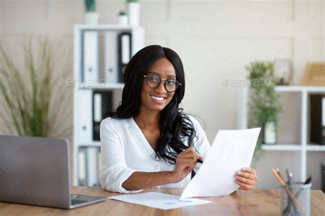 Beautuful Black Business Lady Working With Documents At Desk In Office