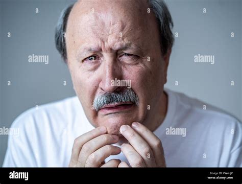 Portrait Of Older Adult Senior Man In Pain With Sad And Exhausted Face