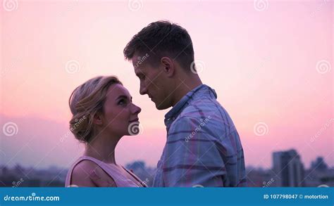 Young Lovers Gazing Into Each Others Eyes Meeting Dawn On Roof Of