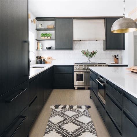 A Beautiful Modern Black Kitchen With Flat Panel Cabinetry And Marble