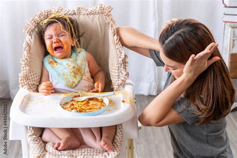 Unhappy Toddler Child With Tomato Sauce On Her Face Crying With Her