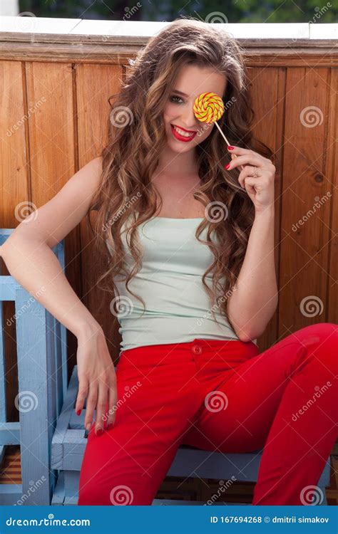 Beautiful Fashionable Woman Eats Delicious Sweet Candy Lollipop On A Stick Stock Photo Image
