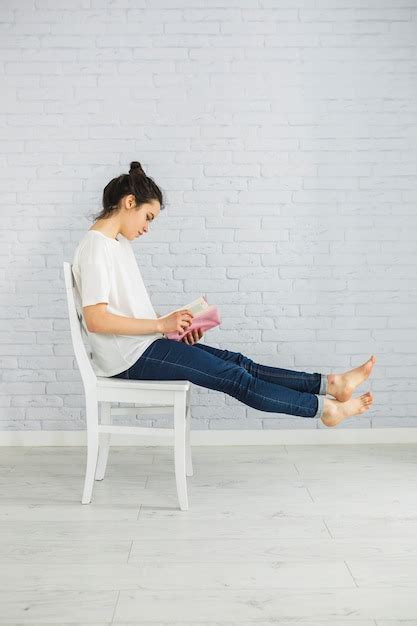Free Photo Barefoot Woman Enjoying Reading On Chair
