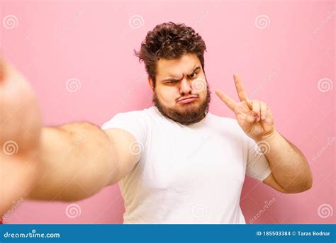Funny Fat Man With Beard Takes Selfie On Pink Background And Shows
